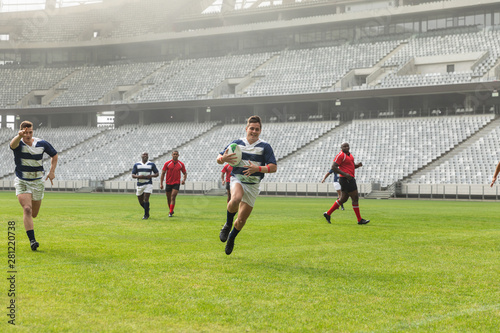 Group of diverse male rugby players playing rugby in stadium © WavebreakMediaMicro