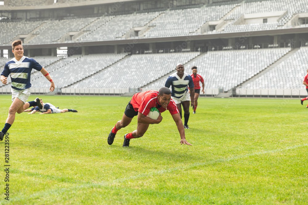 Group of diverse male rugby players playing rugby in stadium Group of diverse male rugby players playing rugby in stadium
