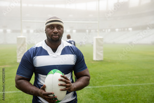 African American Male rugby player holding a rugby ball in stadium