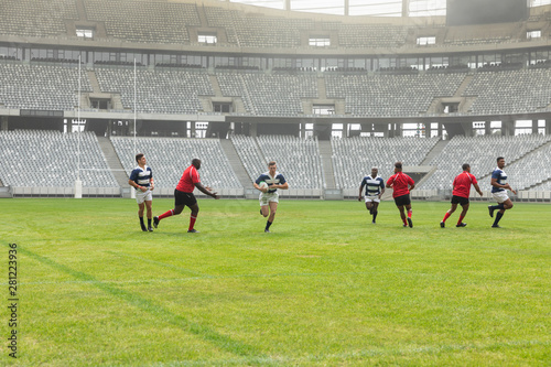 Group of diverse male rugby players playing rugby in stadium