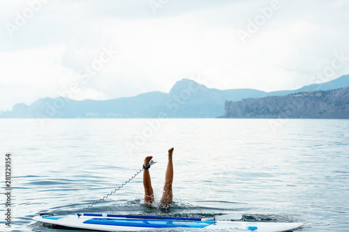 Sports girl on a board for glanders surfing in the sea