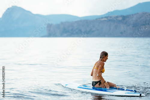 Sports girl on a board for glanders surfing in the sea