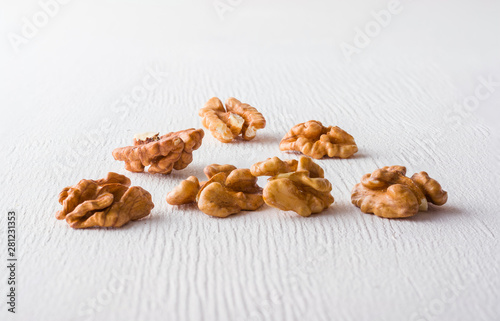 A variety of peeled walnuts and raisins on a white wooden background. View from above. Plenty of space for text.