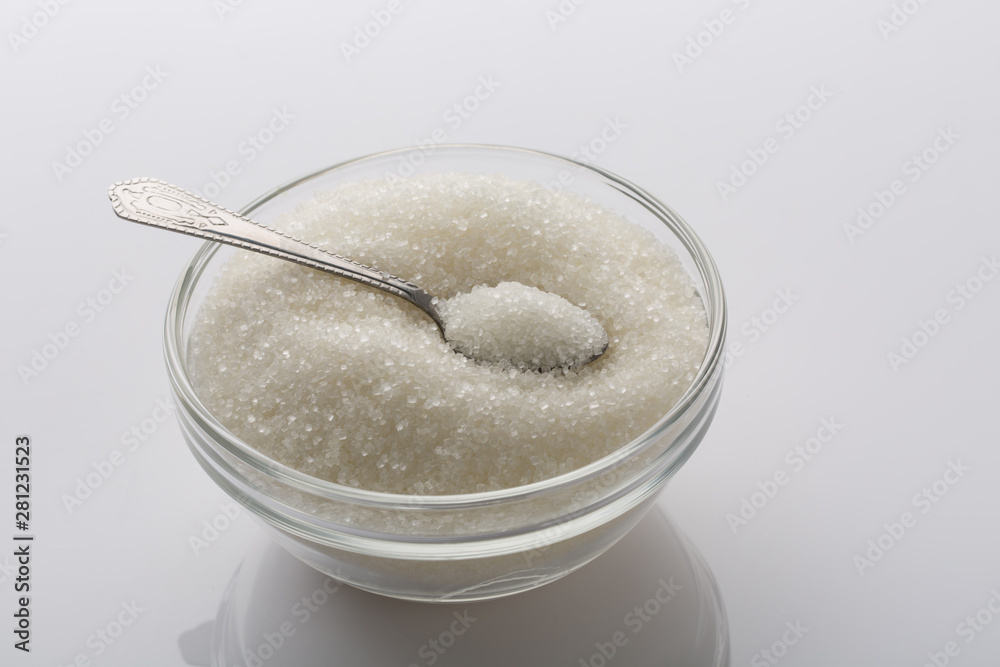 A glass bowl of sugar with spoon