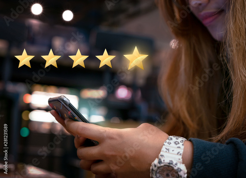 Woman internet shopping on smartphone submitting 5 gold star satisfaction feedback - Millennial girl reply to customer experience survey questions by email - Review, success & retention concept