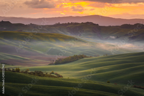 Fantastic sunny spring field in Italy, tuscany landscape morning foggy famous Cypress trees