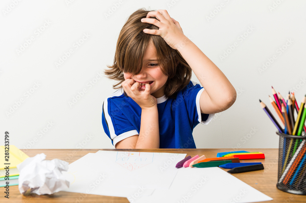 Little boy painting and doing homeworks on his desk biting fingernails, nervous and very anxious. Little boy painting and doing homeworks on his desk biting fingernails, nervous and very anxious.