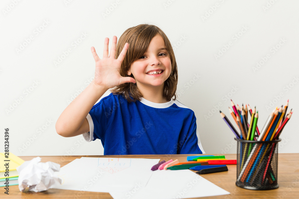 Little boy painting and doing homeworks on his desk smiling cheerful showing number five with fingers. Little boy painting and doing homeworks on his desk smiling cheerful showing number five with fingers.