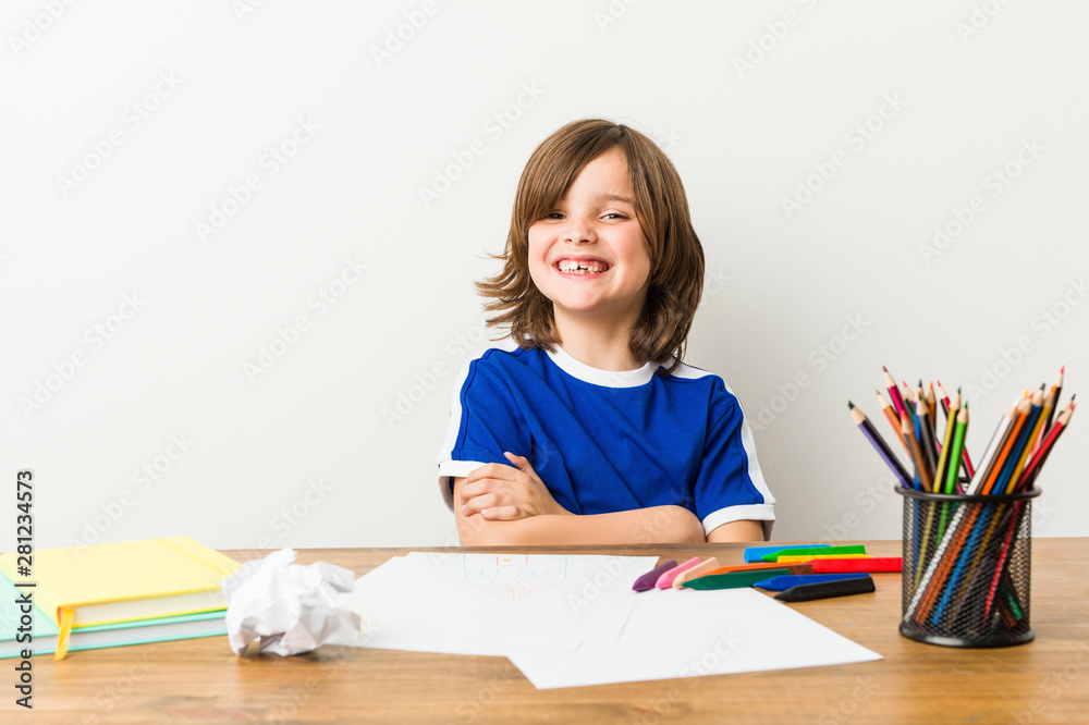 Little boy painting and doing homeworks on his desk laughing and having fun. Little boy painting and doing homeworks on his desk laughing and having fun.