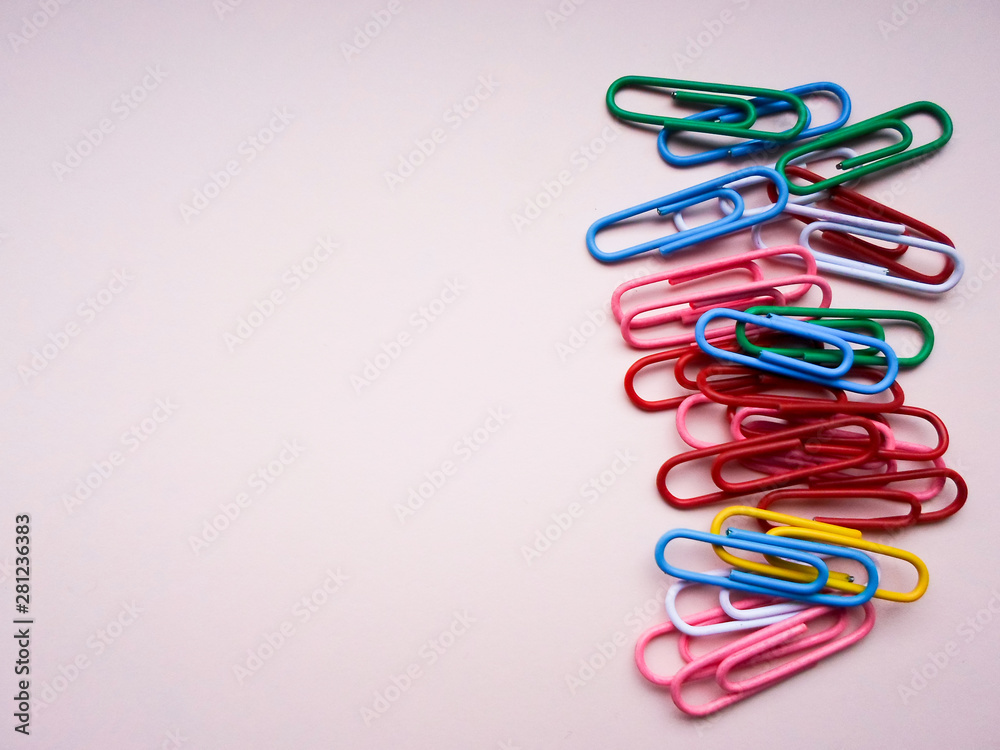 multicolored paper clips on a pink background. The concept is time to school.