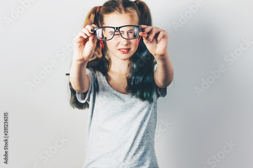 Teen girl holding an eyeglasses in her hands. Selective focus. Look through glasses.