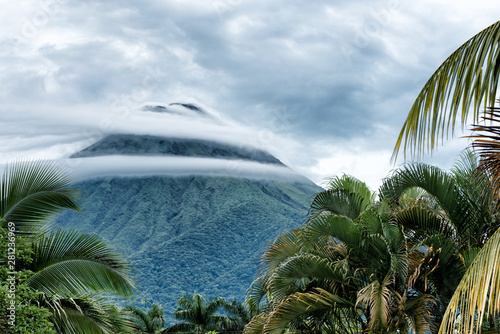 Beautiful and dramatic view of Arenal volcano surrounded by ring clouds. La Fortuna city, costa rica. photo