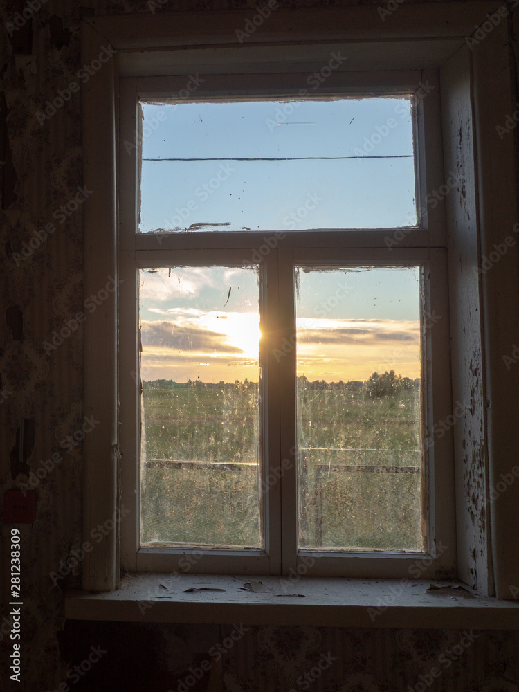 view of summer sunset through old dirty window view of summer sunset through old dirty window