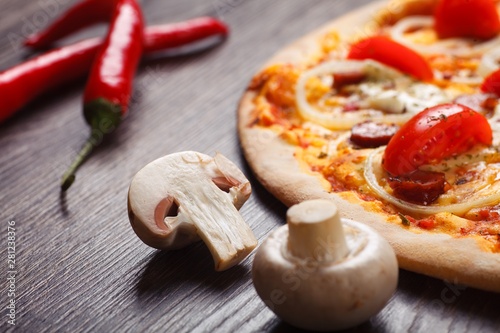 Close up sliced mushroom, peace slice of pizza, red hot pepper on dark wooden background