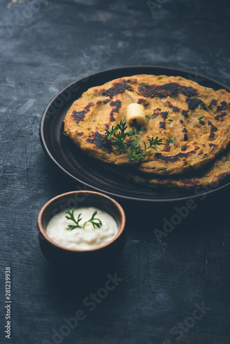 Thalipeeth is a type of savoury multi-grain pancake popular in Maharashtra, India served with curd/butter or ghee photo