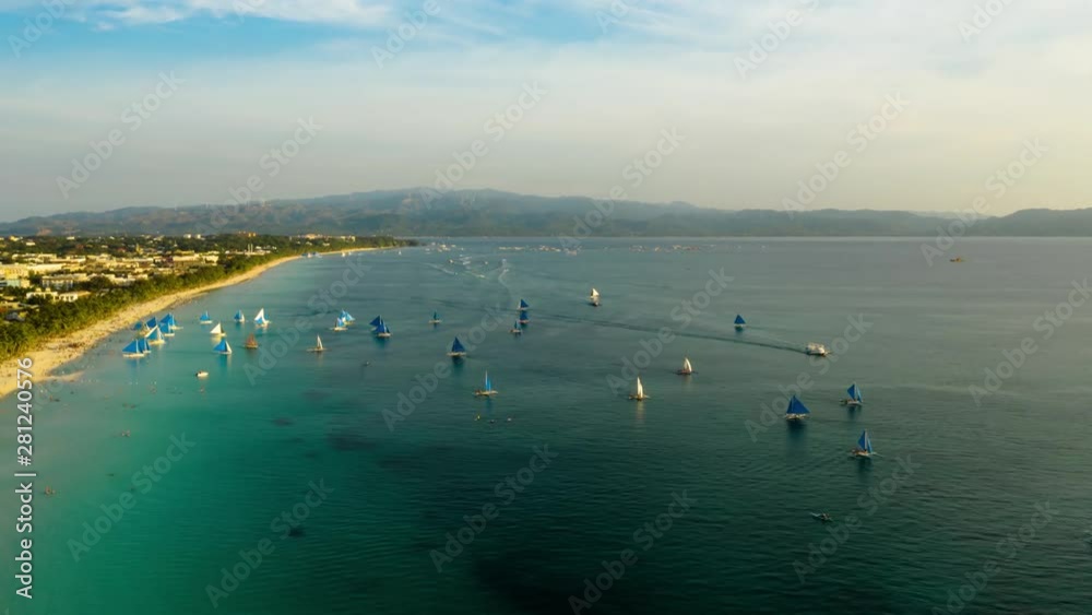 Aerial time lapse of sailing boats on the sandy beach of Boracay Island at sunset time. Hyperlapse: Tropical white beach with sailing boat. Summer and travel vacation concept. Aerial time lapse of sailing boats on the sandy beach of Boracay Island at sunset time. Hyperlapse: Tropical white beach with sailing boat. Summer and travel vacation concept.