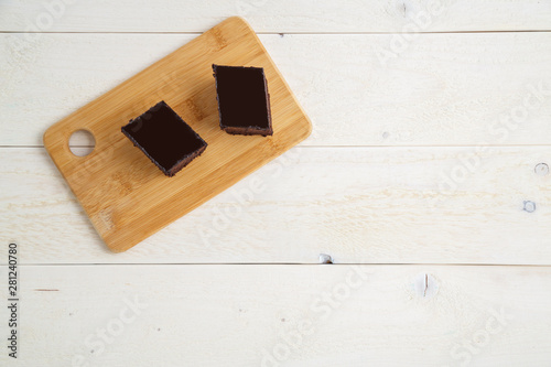 brownie cake on a bamboo tray on a white wooden background with space for textt. top view photo