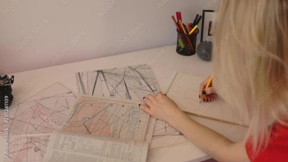 Close up woman draws a pencil on paper at home. Female fashion designer drawing sketches the dress. Fashion designer drawing and paint. Stylish loft studio.