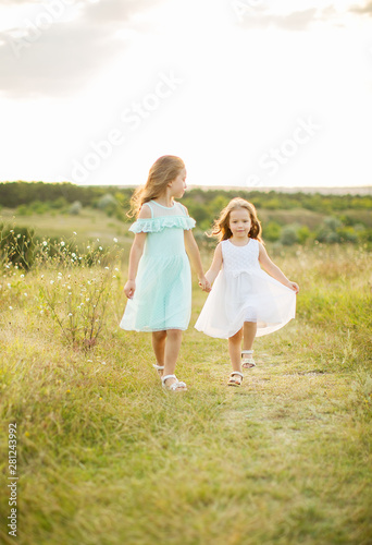 Two adorable girls sisters having fun outdoors.