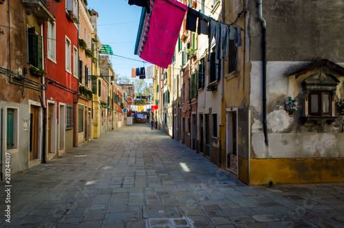 Bucato steso ad asciugare in una calle di Venezia con un tabernacolo dedicato a Sant'Antonio