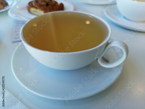 Cup of green tea on white table.