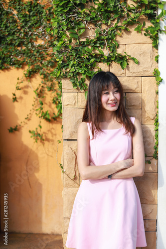 An Asian girl wear pink dress alone and sad in the garden.