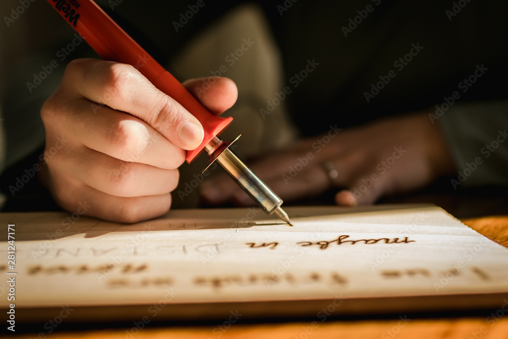 Light and Shadows on a Person Burning Letters into Wood Stock Photo