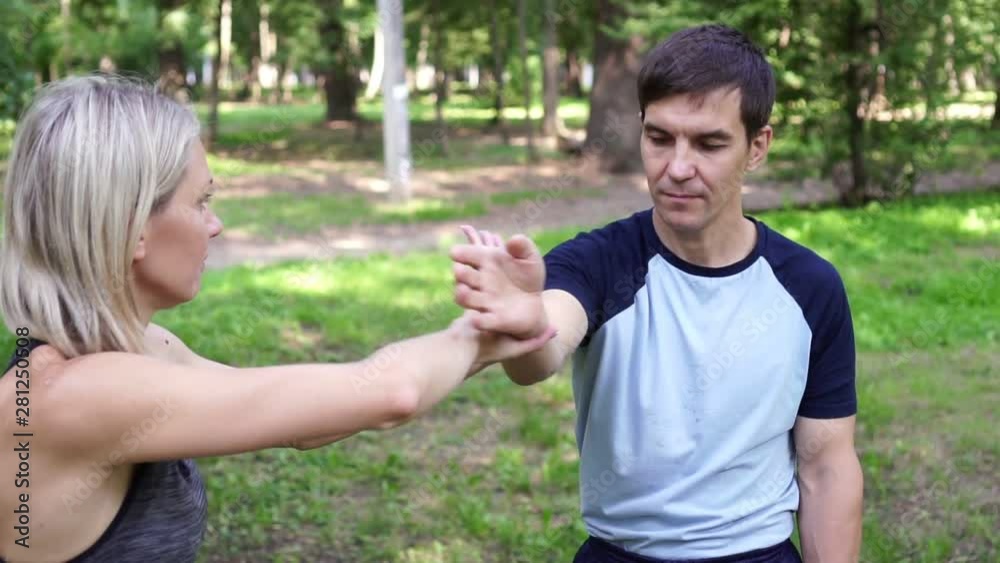 Beautiful woman goes in for sports in the park with a trainer. Beautiful woman goes in for sports in the park with a trainer.