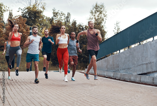 Full length of people in sports clothing jogging while exercising outdoors