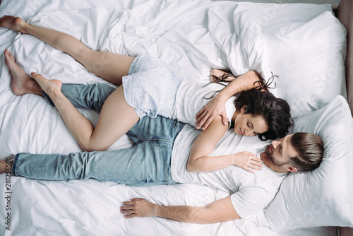 top view of attractive woman and handsome man with closed eyes hugging and sleeping