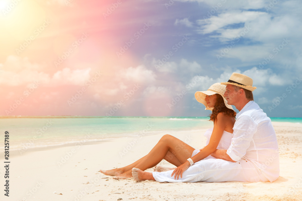 Happy honeymoon vacation at summer. Couple relax on the white sand of beach. Happy sea lifestyle. Young family, man and woman rest on the beach of ocean. Couple in love travel to island. Love travel Happy honeymoon vacation at summer. Couple relax on the white sand of beach. Happy sea lifestyle. Young family, man and woman rest on the beach of ocean. Couple in love travel to island. Love travel