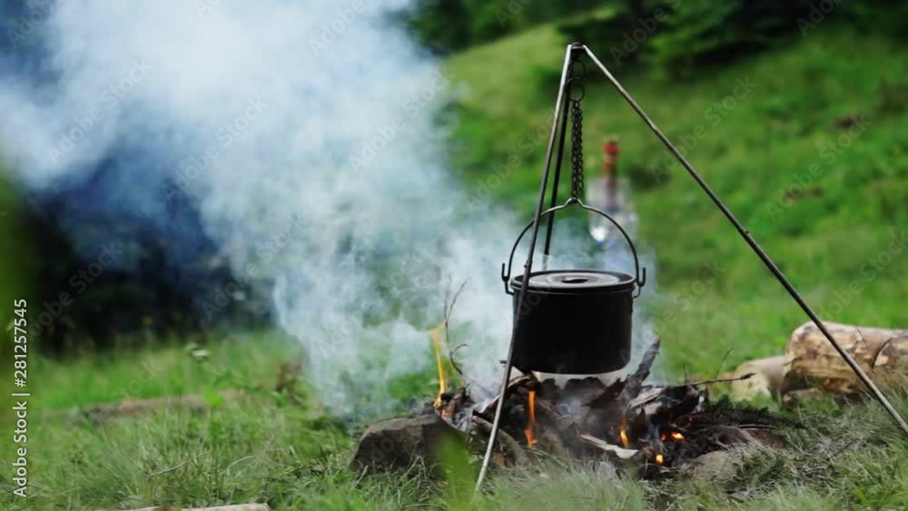 Cooking outdoors in iron cauldron. Cooking outdoors in iron cauldron.