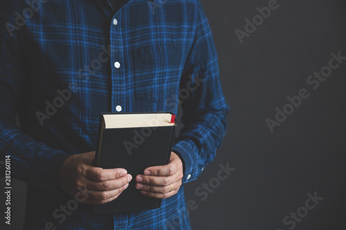 Fototapeta Naklejka Na Ścianę i Meble -  Man is holding and hug the bible in the morning. Hands folded in prayer on a Holy Bible in life concept. worship and religion. copy space