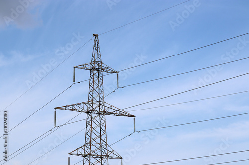 High voltage power line support with electrical wires on blue sky with clouds. Electricity transmission lines, power supply concept