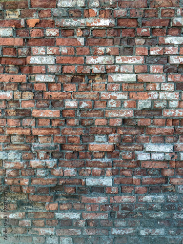 A wall with a torn brick of old age for use as a background or screen saver. Vertical position.