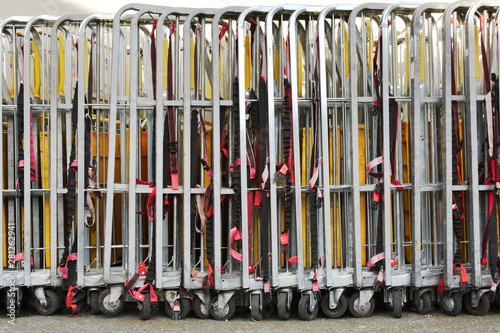 Warehouse trolleys folded and stored in a line with securing straps © Lisa