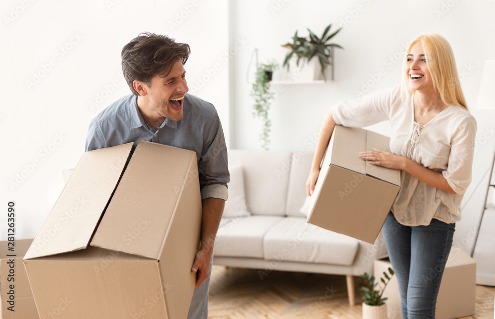 Joyful Couple Carrying Boxes Moving To New Flat