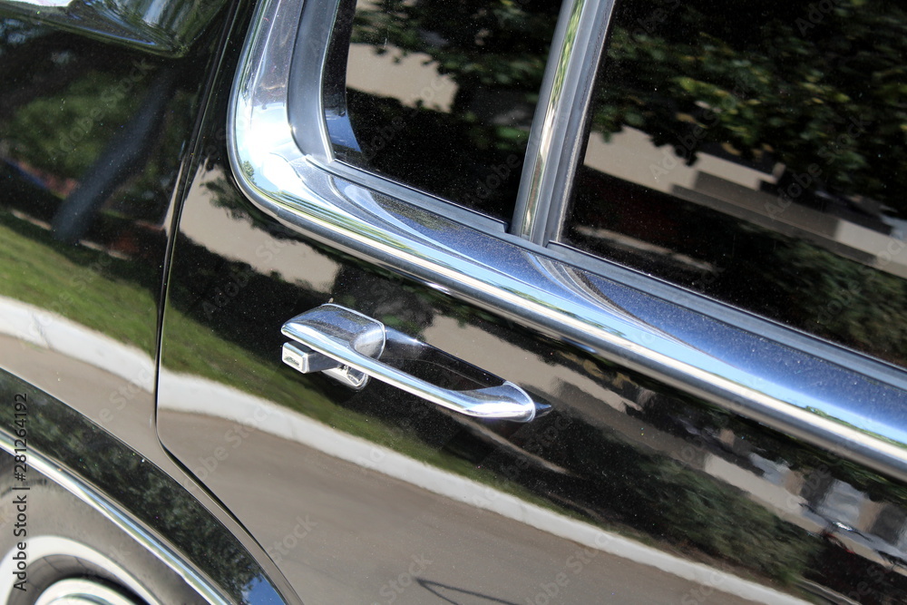 Silver metal handle on a black car