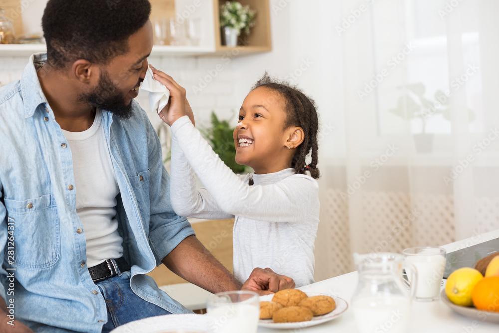 Father and daughter having fun and eating cookies Father and daughter having fun and eating cookies