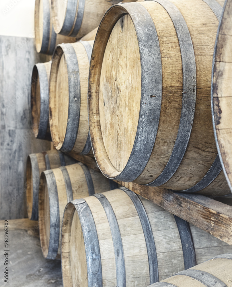 Rows of wine barrels in winery storage in Italy. Can serve as an invitation card. Light High key photography.
