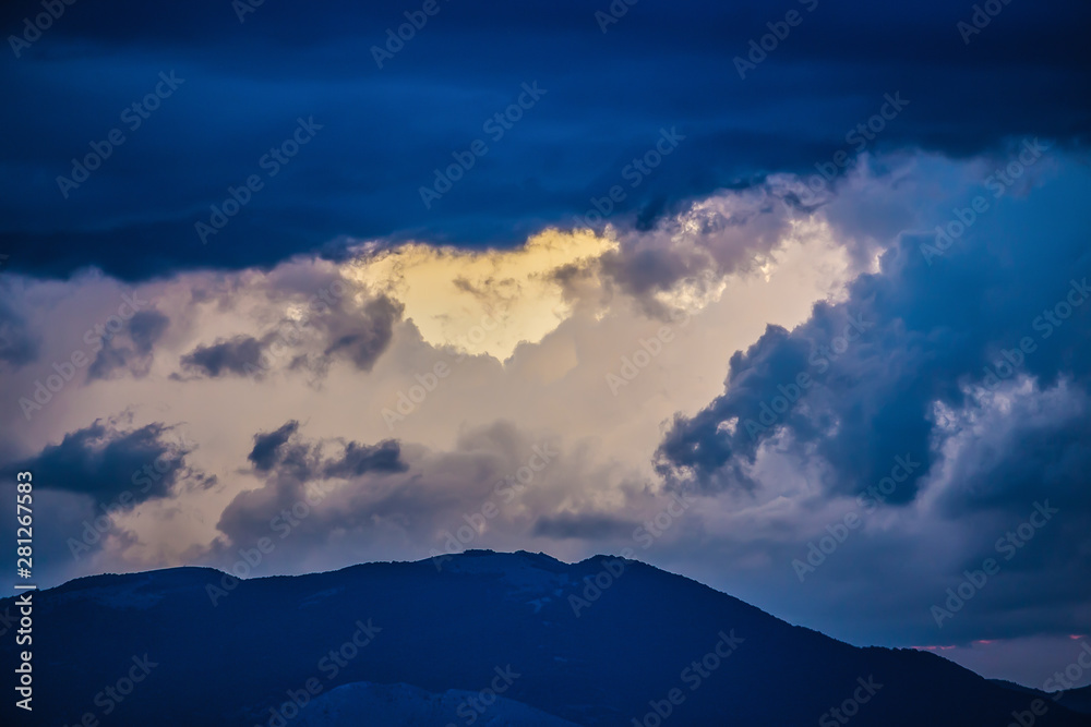 Beautiful sunset in the cloudy sky in the mountains