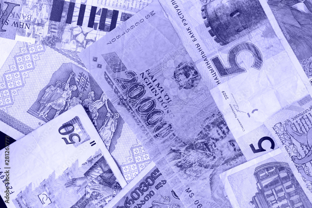 Fototapeta premium Various banknotes from different countries close-up (Belarusian rubles, Georgian lari, Polish zloty, Israeli shekels, Vietnamese dongs). Money background blue color toned
