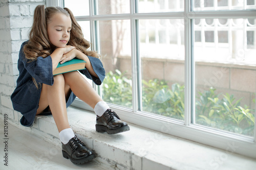Girl schoolgirl reads a book. School fashion. Fashionable school uniform. photo
