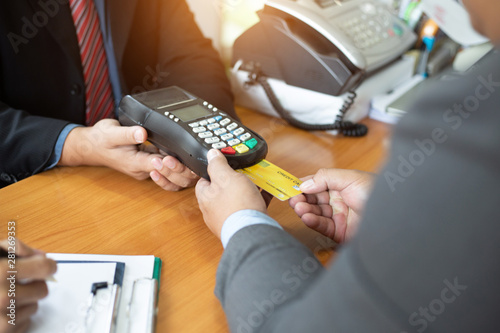 Close up of hands businessman use a credit card swipe to pay for the share transfer fees in the investment of the company.concept of payment