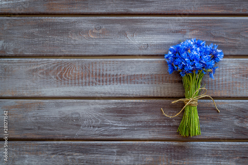 Field flowers design with bouquet of blue cornflowers on wooden background top view space for text