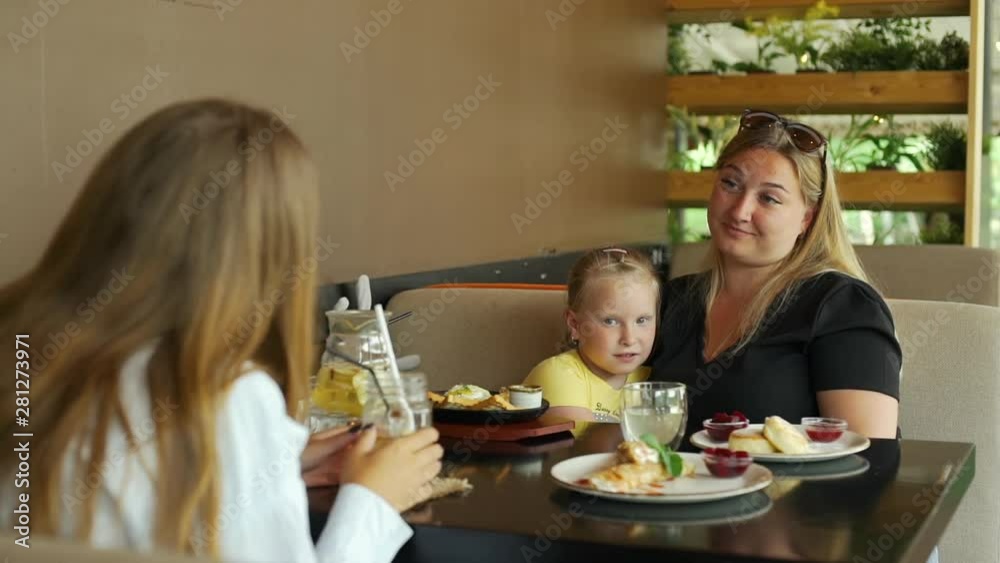Young Mother with Child Meeting with Friend in Cafe. People Talking during Lunch at a Coffee Shop. People, Leisure, Friendship and Communication concept Young Mother with Child Meeting with Friend in Cafe. People Talking during Lunch at a Coffee Shop. People, Leisure, Friendship and Communication concept