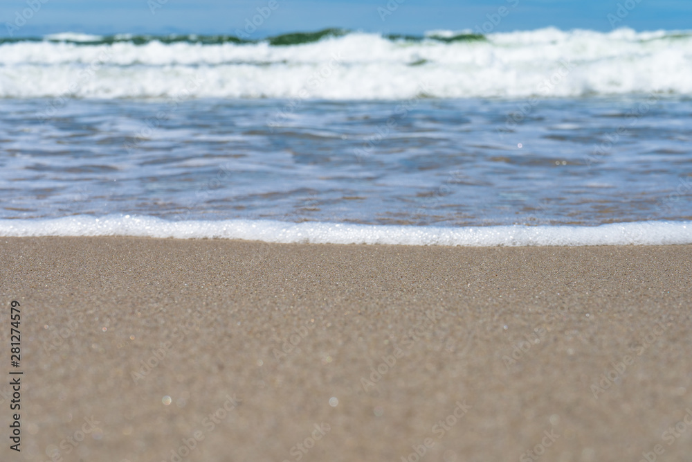 Seaside. A wave is coming. Small grains of sand close up. Concept. Background. Summer is over. Summer sales. Free space for text.