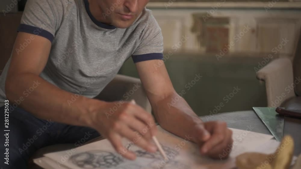 Top bottom shot of an artist drawing the human hand sketch with a pencil. Working in art studio Top bottom shot of an artist drawing the human hand sketch with a pencil. Working in art studio