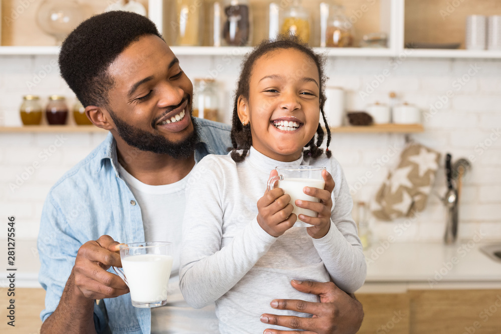 Black girl and her father are laughing while drinking milk Stock Photo