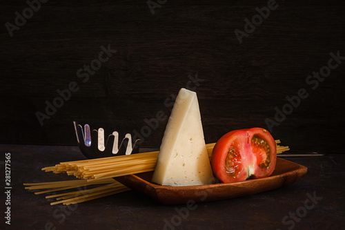 DISH WITH SPAGHETTI, TOMATO AND CHEESE ON DARK FUND photo